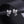 Silver bow-shaped earrings with star charms on a dark background