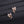 Rose gold bow-shaped earrings with clear stones on a black surface