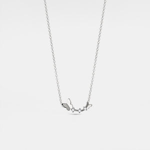 Silver necklace with small pendant on a light gray background
