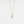 Gold necklace with a pearl pendant on a light gray background