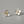 Silver flower-shaped earrings with gold centers on a gray background