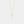 Gold cross necklace on a light gray background