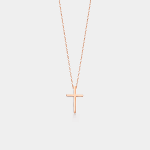 Rose gold cross necklace on a light gray background