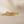 Gold ring with baguette-cut diamonds on a beige background