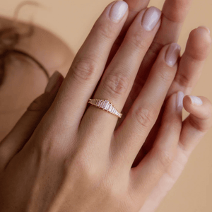 Gold ring on a hand with a neutral background