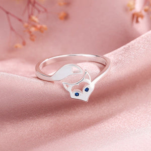 Silver fox-shaped ring with blue stones on a pink fabric background