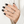 Hand with black nail polish wearing a silver ring on a white background