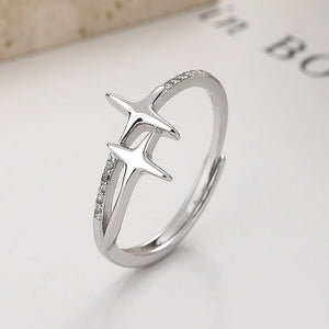 Silver ring with star-like design on a book