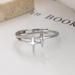Silver ring with star-like design on a book