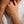 Close-up of a hand wearing a gold bracelet with a star charm on a textured white fabric background.