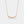 Rose gold necklace with small diamonds on a light gray background