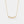 Gold necklace with a floral pendant on a light gray background