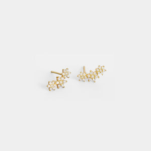 Gold floral stud earrings on a light gray background