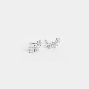 Pair of silver floral earrings on a light gray background