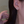 Close-up of a woman wearing a floral earring with a dangling chain.