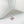 Pink flower-shaped pendant on a silver chain against a white background