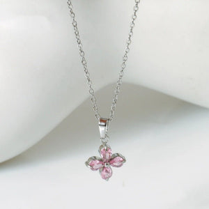 Pink flower-shaped pendant on a silver chain against a white background