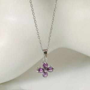 Silver necklace with a purple flower-shaped pendant on a white background