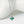 Silver necklace with a green gemstone pendant on a white background