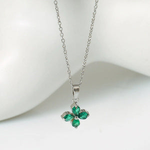 Silver necklace with a green gemstone pendant on a white background