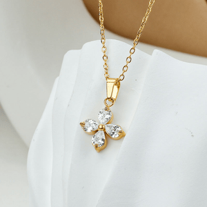 Gold necklace with a diamond pendant on a white surface