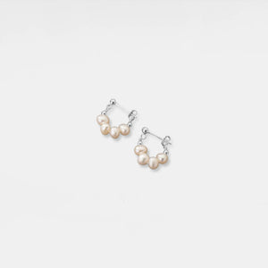 Pair of pearl hoop earrings on a light gray background