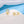 Gold hoop earrings with clear gemstones on a white and blue background