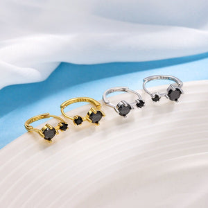 Three rings in gold, silver, and black on a white surface with a blue background