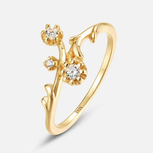 Gold ring with floral design and diamonds on a white background