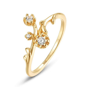 Gold ring with floral design and diamonds on a white background