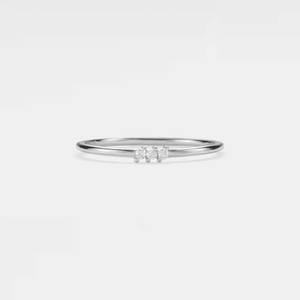 A set of thin gold-colored bands with green and clear cubic zirconia accents on a white background.