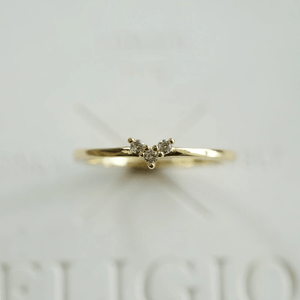 Gold ring with small diamonds on a light gray background
