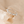 Silver earring with pearls on a beige stone background
