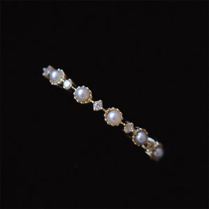 Pearl and diamond ring on a black background