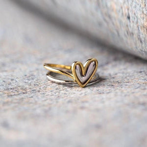Gold heart-shaped ring on a textured surface