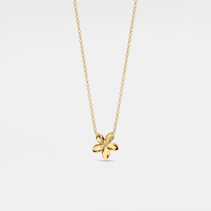 Gold necklace with a four-leaf clover pendant on a light gray background