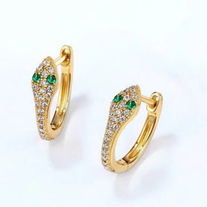 Gold hoop earrings with green gemstones on a white background