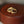 Two gold rings on a brown leather surface