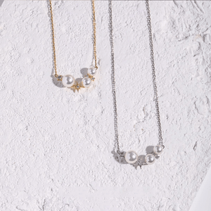 Two pearl necklaces on a textured white surface