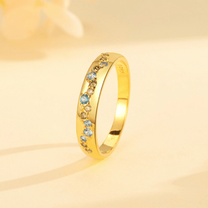 Gold ring with embedded gemstones on a gold background