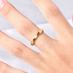 Gold star ring on a person's finger against a light background