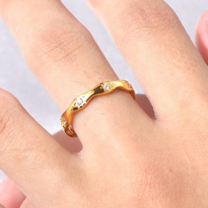 Gold star ring with small cubic zirconia on a finger against a light background
