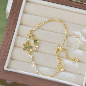 Gold bracelet with green gemstones in a jewelry box