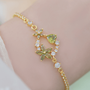 Gold bracelet with green gemstones on a person's wrist