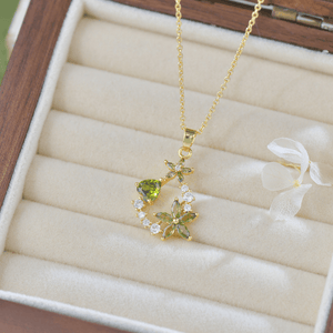 Gold necklace with green gemstones in a jewelry box