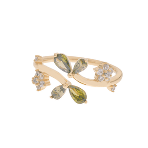 Gold bracelet with green teardrop stones and clear gemstones on a white background