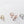Three pairs of earrings in gold, rose gold, and silver on a light gray background