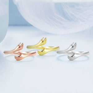 Three pairs of gold and silver cufflinks on a light blue fabric background