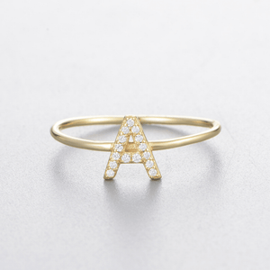 Gold ring with letter 'A' design on a light gray background