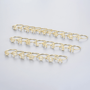 Set of gold lettered bracelets on a light gray background